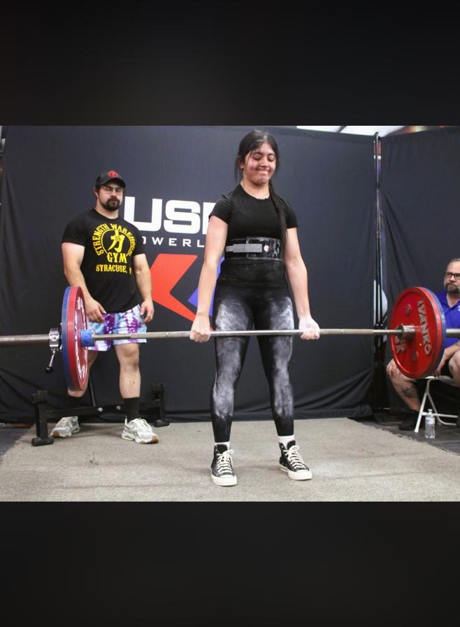 Fatima performing a deadlift during competition