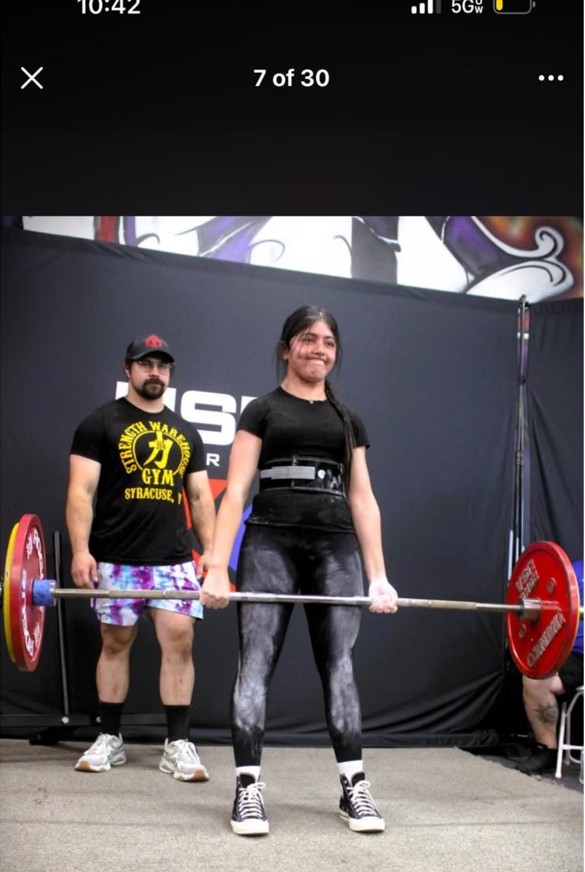 Fatima tu Zahra performing a deadlift at competition